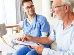 Doctor discussing medical care with an elderly patient during a healthcare consultation, focusing on patient communication and support.